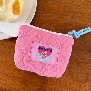 Vista dettagliata della pochette in cotone rosa trapuntato con motivo a cuore e zip