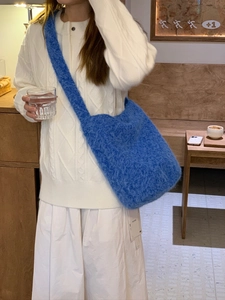 Detail of Klein blue plush knit bucket bag with soft texture and wide shoulder strap