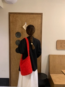 Detailed view of the bright red plush shoulder bag made of soft faux mohair material