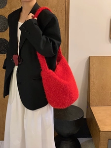 Close-up of bright red plush hobo bucket bag with soft faux mohair texture and large capacity