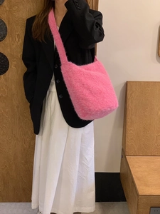 Detail of pink faux fur bucket bag showing soft plush texture and shoulder strap
