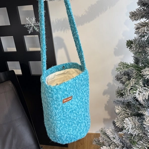 Close-up of blue fleece bucket bag with magnetic closure and inner lining