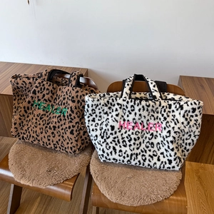 Detail der Leopard-Plüsch-Tragetaschen mit HEALER-Stickerei in zwei modischen Farben