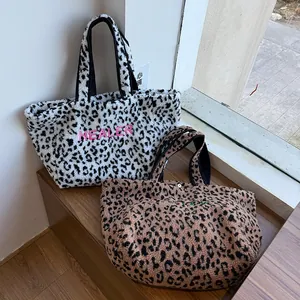 Detailansicht zweier Plüsch-Tote-Bags mit Leopardenmuster und HEALER-Stickerei