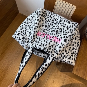 Nahaufnahme der Leopardenmuster-Felltasche mit rosa HEALER Stickerei und Druckknopf