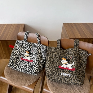 Détail de l'écusson chiot brodé et texte sur des sacs fourre-tout en toile léopard