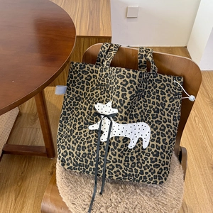 Détail du sac cabas léopard en toile avec broderie dalmatien et nœud en ruban noir