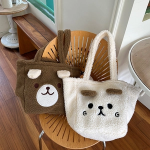 Detail of plush lamb wool tote bags featuring cute bear and puppy face embroidery