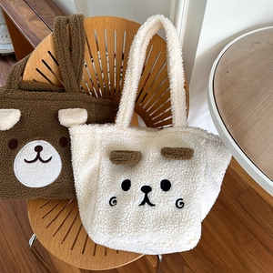 Detail of plush bear tote bags showing 3D ears and embroidered faces in brown and cream
