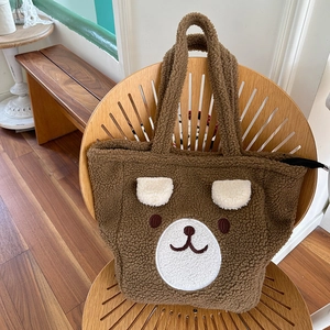 Detail of plush bear tote bag with 3D ears on a wooden chair in warm lighting