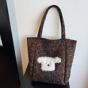 Close-up of leopard print suede tote bag featuring a cute 3D plush puppy patch detail