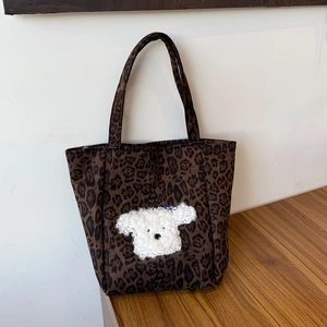 Detailed view of leopard print suede tote bag featuring a cute plush animal patch applique