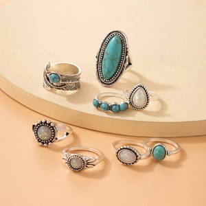 Detail of 8-piece vintage bohemian ring set with turquoise and feather carvings