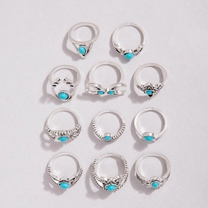 Close-up of 11-piece vintage silver ring set with turquoise stones and floral engravings