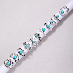 Detailed close-up of bohemian silver rings with turquoise stones on a white stand