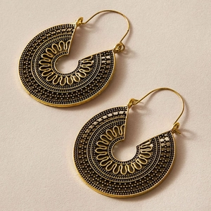 Detaillierte Nahaufnahme goldener Bohemian-Ohrringe mit feinen ethnischen Mustern im C-Design