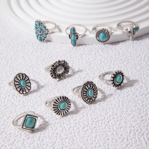 Detailed close-up of 10-piece vintage silver rings with turquoise stones on white marble