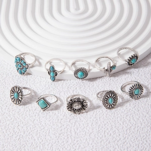 Close-up of a 10-piece vintage silver ring set with turquoise floral and cactus designs