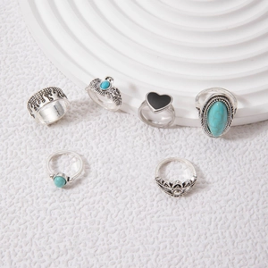 Detail of 6-piece bohemian silver ring set featuring turquoise stones and elephant relief