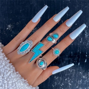 Detailed view of vintage silver bohemian rings set with turquoise on a model's hand