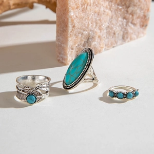 Detail of vintage boho turquoise ring set featuring engraved leaf patterns and oval stone
