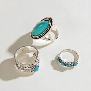 Detailed view of bohemian vintage silver rings set with turquoise and feather texture