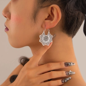 Vintage bohemian silver earrings with hollow floral mandala design on female model