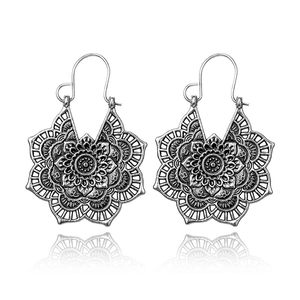 Detailed view of antique silver earrings with intricate mandala hollow patterns