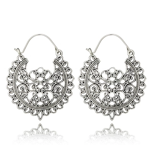 Close-up of bohemian hollow carved horseshoe earrings with intricate vintage silver details