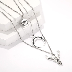 Détail du collier à plusieurs rangs avec pendentifs œil, lune et crâne de taureau