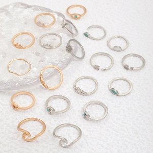 Flat lay of retro bohemian stacking rings with turquoise accents and celestial motifs