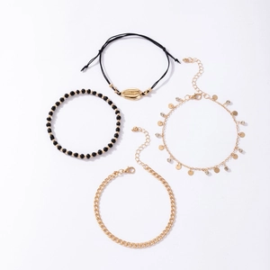 Detail of 4-piece beach anklet set featuring golden shell charm and beaded rope chains