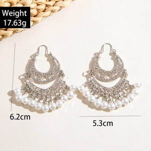 Detailed view of bohemian silver-tone crescent earrings with white pearls and tassels