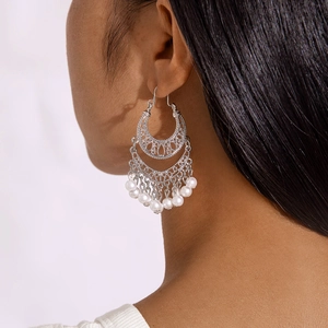 Detailed view of silver bohemian crescent moon earrings with intricate hollow metalwork
