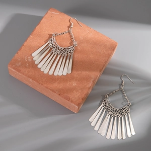 Detailed shot of ethnic silver tassel earrings with hollow crescent and drop pendants