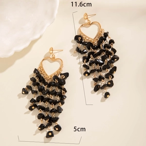 Detailed view of 11.6cm long tassel heart earrings with golden finish and black stones