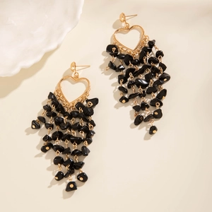 Close-up of bohemian hollow heart earrings with elegant black stone tassel details