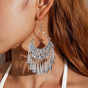 Bohemian silver hollow crescent earrings with conical tassels on model close-up