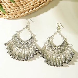 Detailed close-up of vintage silver bohemian tassel earrings with hollow crescent design