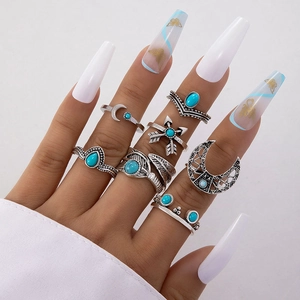 Detail shot of bohemian silver rings set with turquoise, moon and feather motifs