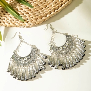Detailed macro of vintage bohemian tassel earrings with hollow out moon patterns