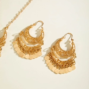 Detail of bohemian gold hollow crescent earrings with dangling metallic sequins