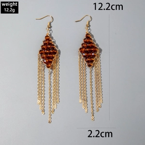 Detailed view of U-shaped gold tassel earrings with amber beads and size dimensions