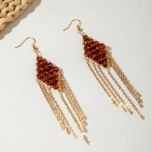 Detail of bohemian gold tassel earrings with amber crystal beads and long chain fringe