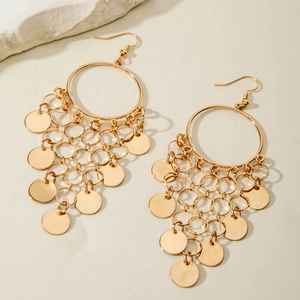 Detailed macro view of vintage golden U-shaped tassel earrings with hollow round plates