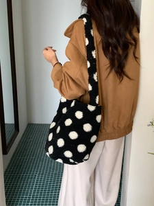Détail d'un grand sac cabas en laine d'agneau noire à gros pois blancs pour l'hiver