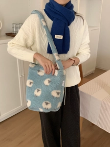 Gros plan du cabas en polaire bleu clair avec motif de mouton et texture douce et pelucheuse