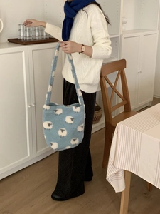 Détail du sac cabas en polaire bleu clair avec une broderie d'agneau blanc et texture douce