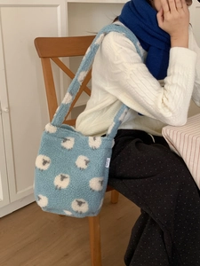 Détail du sac cabas en laine d'agneau avec motif mouton blanc et étiquette en tissu doux