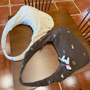 Gros plan de sacs en velours côtelé avec broderies et pendentif chiot en peluche